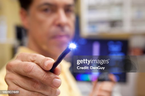 Doctor testing lighted probe used for endoscopy testing Doctor testing lighted probe used for endoscopy testing