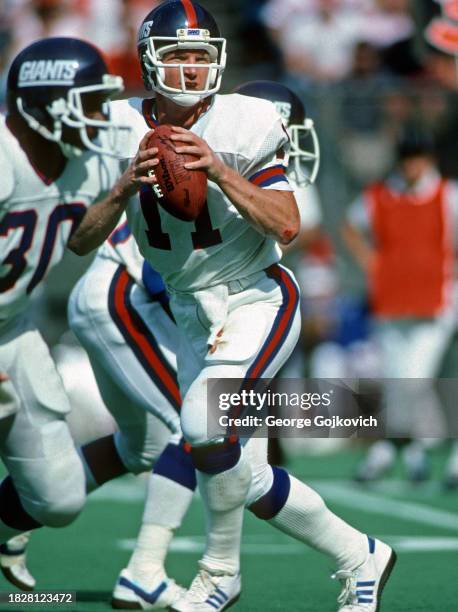 Quarterback Phil Simms of the New York Giants looks to pass against the Cincinnati Bengals during a game at Riverfront Stadium on October 13, 1985 in...