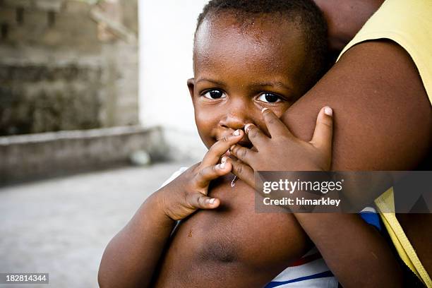 small african baby boy embracing his mothers comforting arm - africa stockfoto's en -beelden