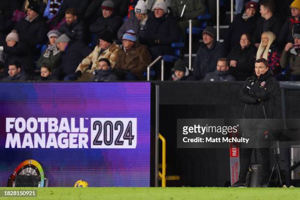 Paul Heckingbottom, Manager of Sheffield United, stands beside a Football Manager 2024 advertisement during the Premier League match between Burnley...