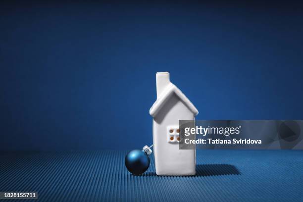 white ceramic house and christmas bauble on blue night background - white house christmas stock pictures, royalty-free photos & images