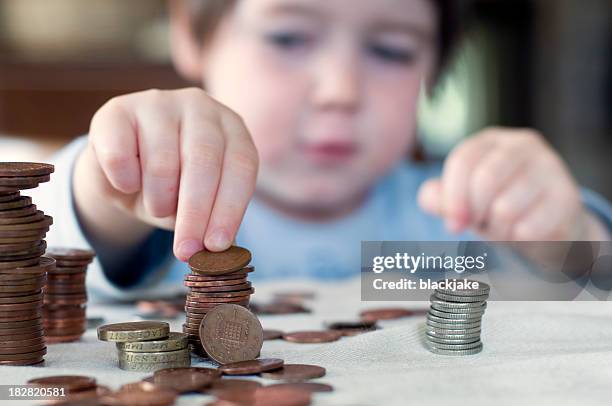 a young boy counting his piggy bank money - zakgeld stockfoto's en -beelden