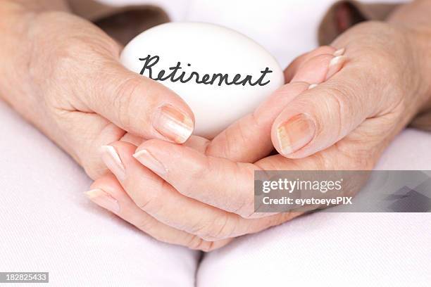 elderly woman holding retirement egg - nest egg stock pictures, royalty-free photos & images