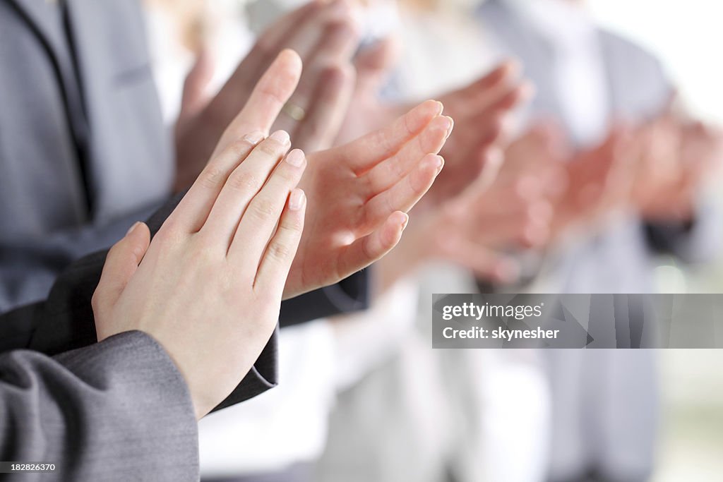 Photo of business partners hands applauding at meeting.