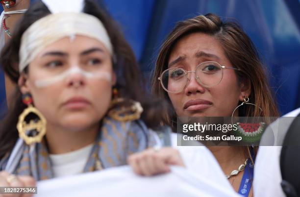 Activists, including Filipino environmental activist Mitzi Jonelle Tan , who is wearing an earring that looks like a watermelon, a symbol of...