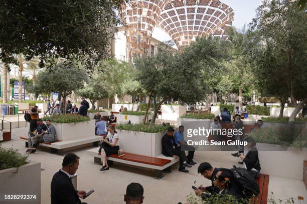 Participants sit in the shade outside on day four of the UNFCCC COP28 Climate Conference at Expo City Dubai on December 03, 2023 in Dubai, United...