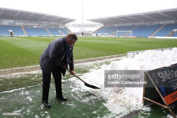 Groundsman is seen sweeping snow prior to the Emirates FA Cup Second Round match between Chesterfield and Leyton Orient at Technique Stadium on...