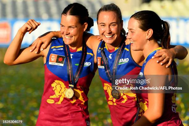 Sophie Conway, Natalie Grider and Dee Heslop of the Lions celebrate after winning the AFLW Grand Final match between North Melbourne Tasmania...