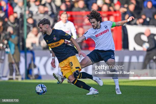 Mael Corboz of Verl tackles Lars Buenning of Dresden during the 3. Liga match between SC Verl and Dynamo Dresden at SPORTCLUB Arena on December 03,...