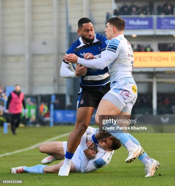 Joe Cokanasiga of Bath Rugby is tackled by Ben Hammersley and Henry Slade of Exeter Chiefs during the Gallagher Premiership Rugby match between Bath...