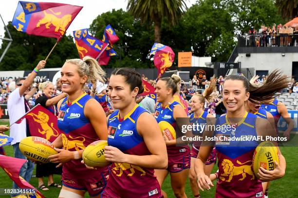 Orla O'Dwyer, Ally Anderson and Jade Ellenger of the Lions run out onto the field during the AFLW Grand Final match between North Melbourne Tasmania...