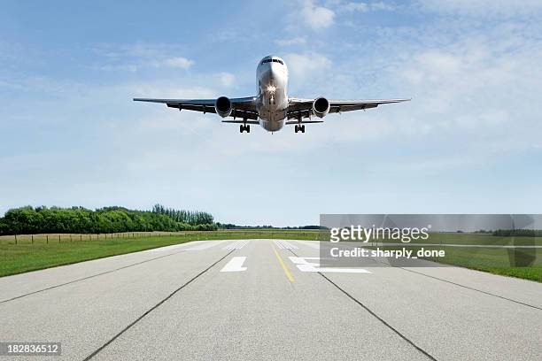 xl jet avión aterrizando en pista - aterrizar fotografías e imágenes de stock