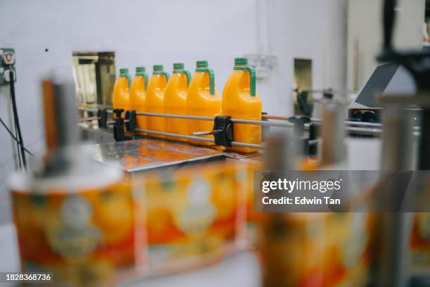 production line of bottled juice beverage moving on conveyor belt in factory - bottling plant stock pictures, royalty-free photos & images