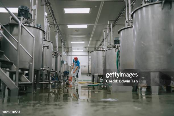 fabrikarbeiter reinigen bodenbeläge innenlagertankabschnitt der fabrik filtermaschine und tanks nach abschluss der produktion - müllmann stock-fotos und bilder