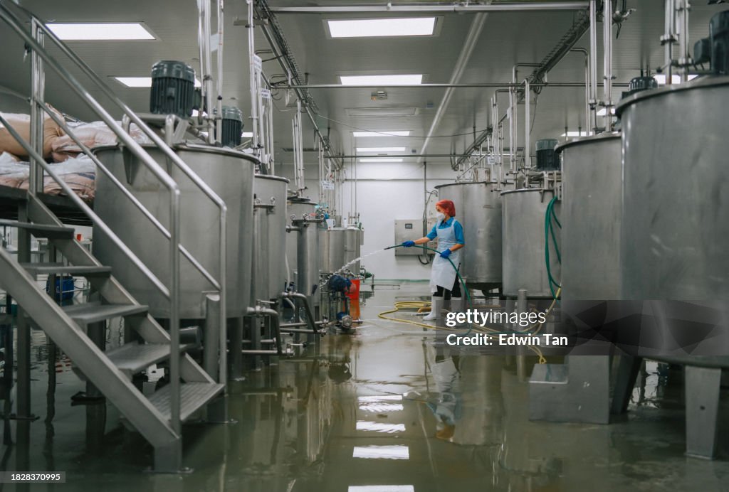 Fabrikarbeiter reinigen Bodenbeläge Innenlagertankabschnitt der Fabrik Filtermaschine und Tanks nach Abschluss der Produktion