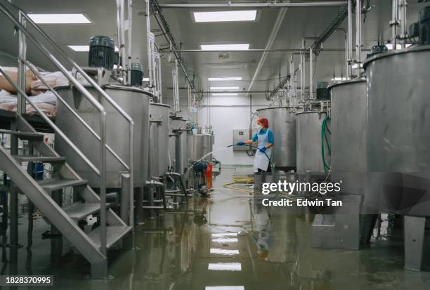 trabalhador da fábrica limpeza do piso seção do tanque de armazenamento interior da fábrica máquina de filtragem e tanques após a produção concluída - industrial cleaning - fotografias e filmes do acervo