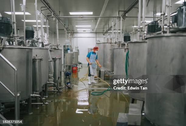 factory worker cleaning flooring factory interior storage tank section filtering machine and tanks after production completed - bomba de água equipamento imagens e fotografias de stock