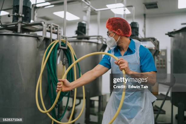 factory worker cleaning flooring factory interior storage tank section filtering machine and tanks after production completed - water tower storage tank stock pictures, royalty-free photos & images