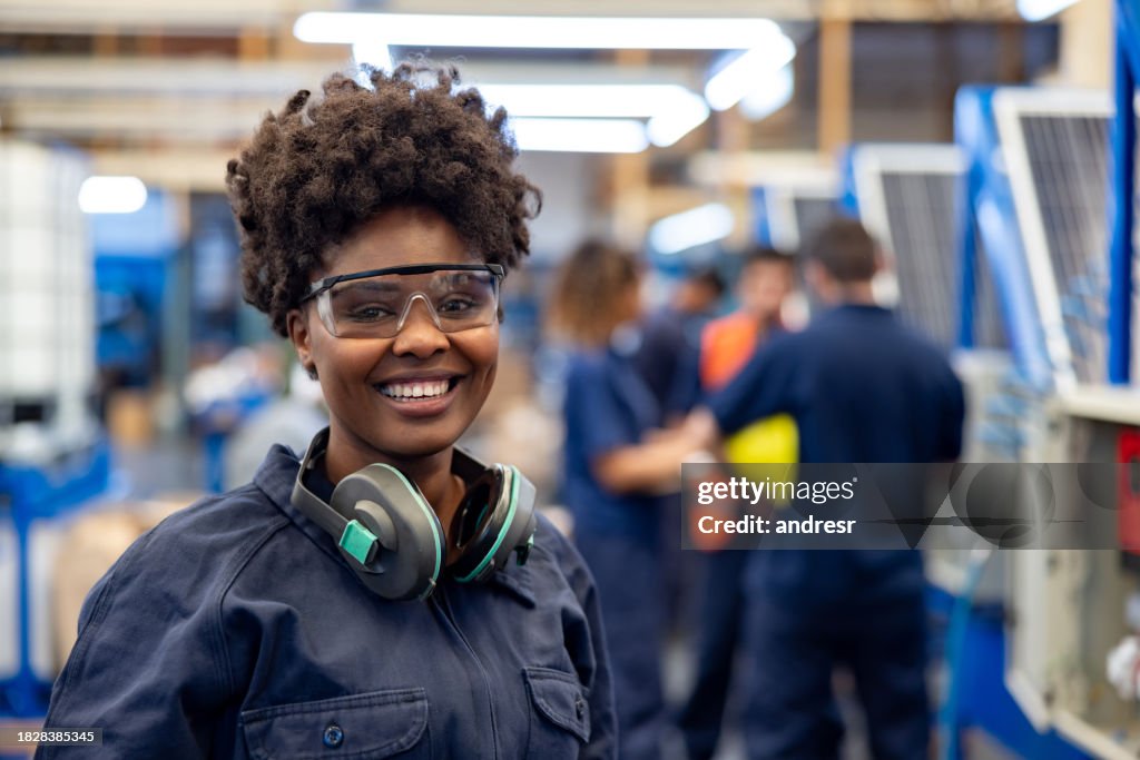Happy employee working at a solar panel factory