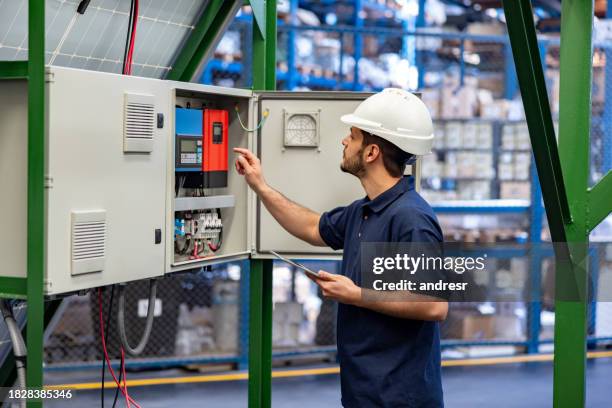 ingenieur repariert den sicherungskasten eines solarmoduls in einer fabrik - schaltschrank stock-fotos und bilder