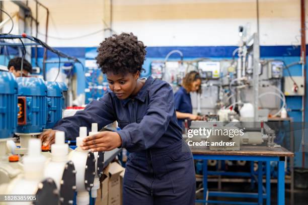 woman working at a water pump factory - operário de linha de produção imagens e fotografias de stock