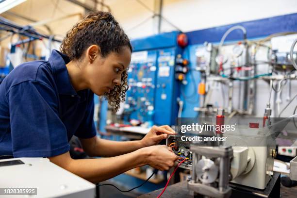 mitarbeiterin, die in einer produktionsfabrik arbeitet - industriearbeiter stock-fotos und bilder