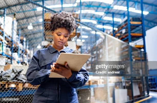 blue-collar worker working at an industrial warehouse taking inventory - warehouse worker stock pictures, royalty-free photos & images