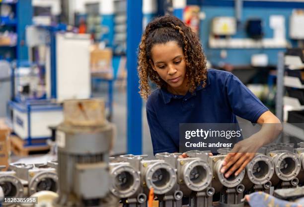 donna che lavora in una fabbrica di pompe idrauliche - operaio di produzione foto e immagini stock