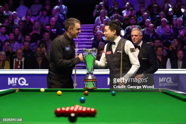 Ronnie O'Sullivan of England and Ding Junhui of China interact before their Final match on Day Nine of the MrQ UK Snooker Championship 2023 at York...