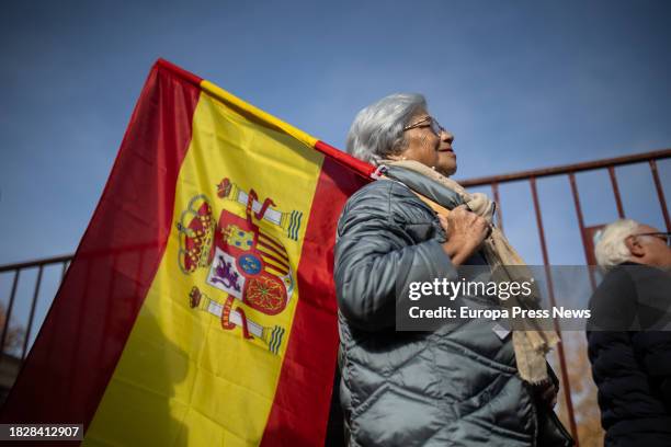 Una mujer lleva una bandera española durante un acto del PP contra la amnistia se dirigen a Ferraz, a 3 de diciembre de 2023, en Madrid . El Partido...