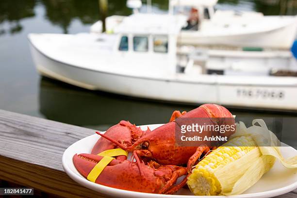 lobster dinner with motor boat on background - lobster dinner stock pictures, royalty-free photos & images
