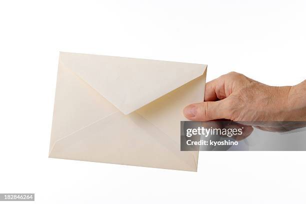 isolated shot of holding an old envelope against white background - yellow envelope stock pictures, royalty-free photos & images
