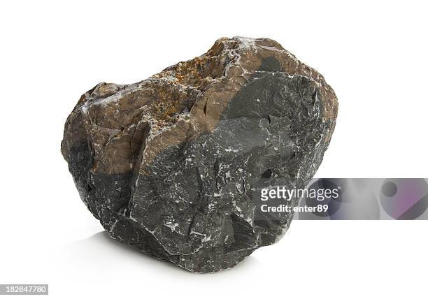 a solid dark rock on a white background - rock object stock pictures, royalty-free photos & images