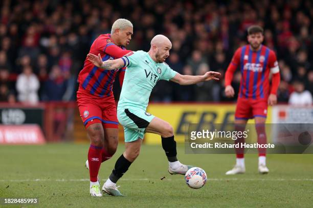 Paddy Madden of Stockport County runs with the ball under pressure from Coby Rowe of Aldershot Town during the Emirates FA Cup Second Round match...