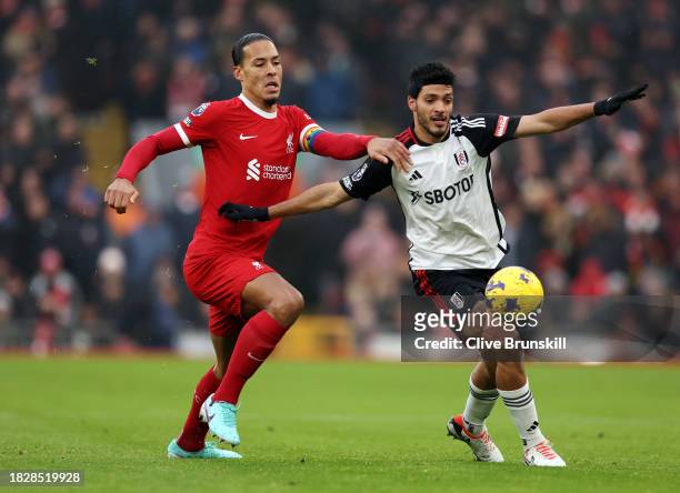 Virgil van Dijk of Liverpool battles for possession with Raul Jimenez of Fulham during the Premier League match between Liverpool FC and Fulham FC at...