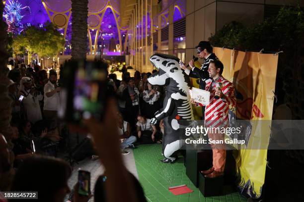 Activists with an effigy of a dinosaur present the daily Fossil award for the country doing the least to mitigate climate change on day four at night...