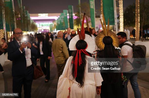 Man photographs indigenous participan on day four at night of the UNFCCC COP28 Climate Conference at Expo City Dubai on December 03, 2023 in Dubai,...