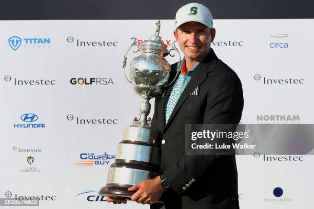 Dean Burmester of South Africa celebrates with the trophy after winning on the 18th green during day four of the Investec South African Open...