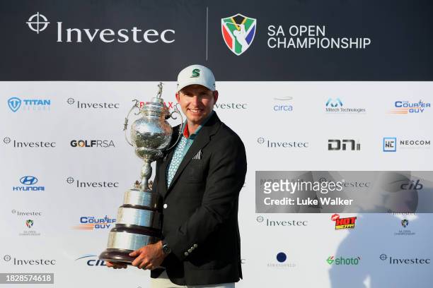 Dean Burmester of South Africa celebrates with the trophy after winning on the 18th green during day four of the Investec South African Open...