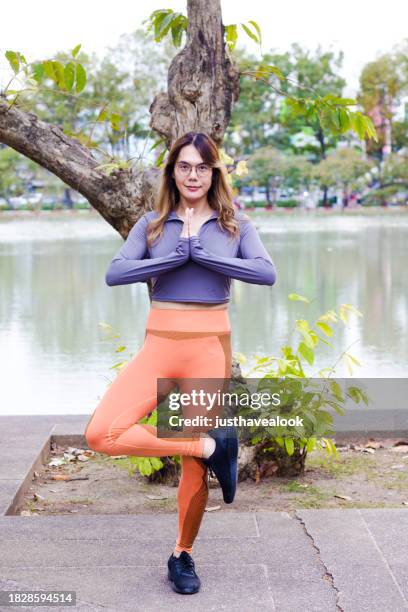 thai transgender standing in yoga position outdoors - kathoey stock pictures, royalty-free photos & images