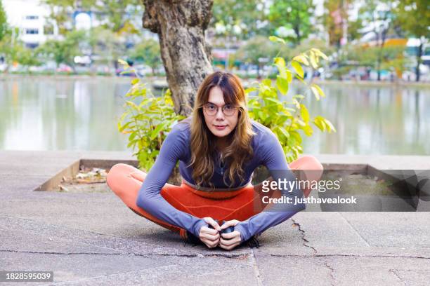 thai transgender sitting sitting and stretching hips  in  yoga position - kathoey stock pictures, royalty-free photos & images