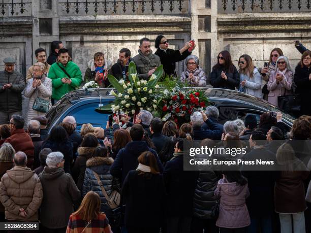 Varias personas observan la salida del feretro hacia el cementerio tras el funeral de la actriz Concha Velasco, en la Catedral de Nuestra Señora de...