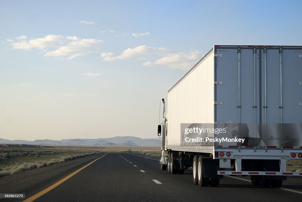 Transporting White Trailer Truck Driving on the Open Road Highway