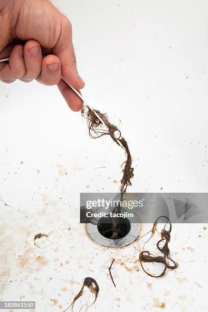 pulling hair from a drain - fontein stockfoto's en -beelden