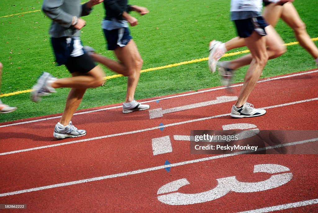 Runners Speed by on Running Track