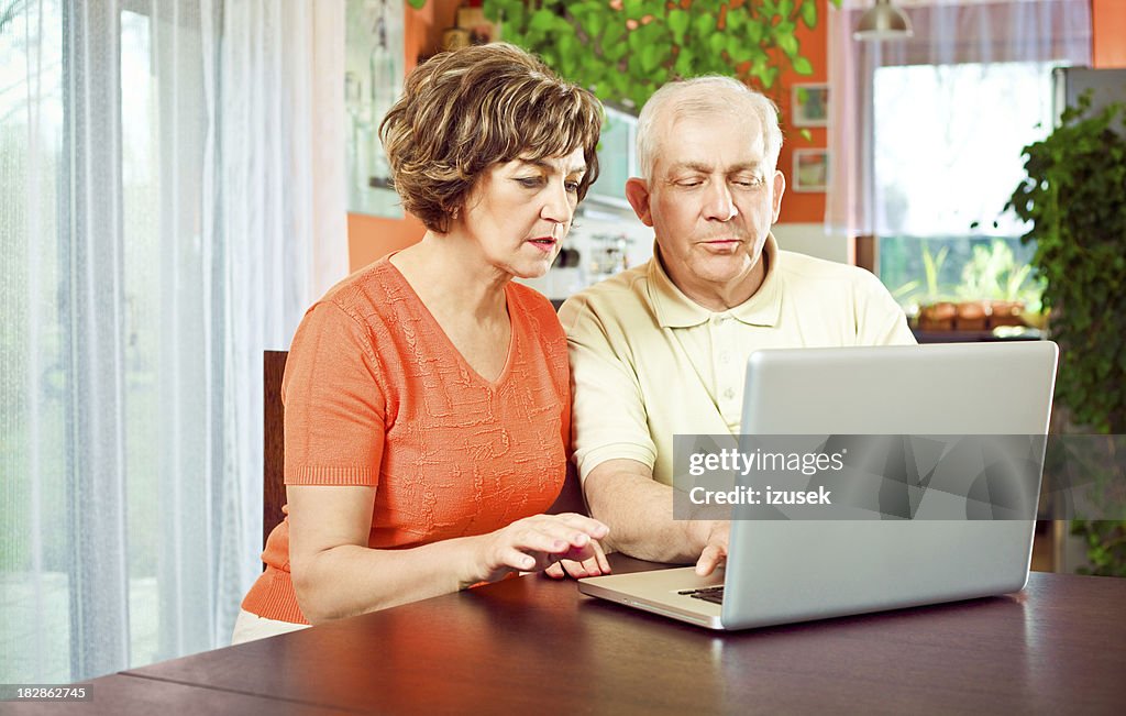 Senior par usando la computadora portátil