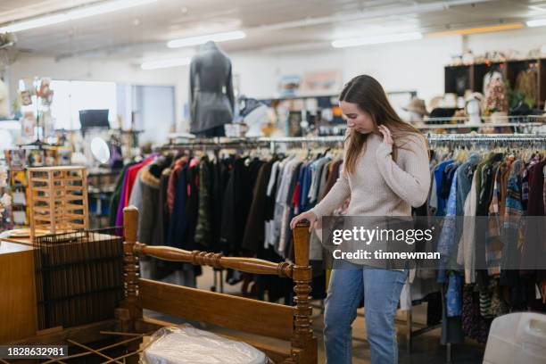 young woman shopping at second hand thrift store in city - duurzaam consumeren stockfoto's en -beelden