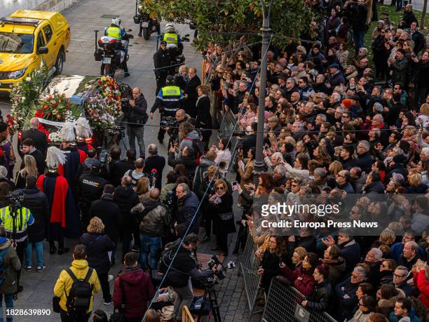 Decenas de personas observan la salida del coche funebre hacia el cementerio tras el funeral de la actriz Concha Velasco, en la Catedral de Nuestra...