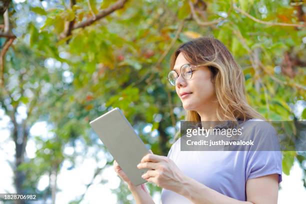 thai transgender sketching  with digital tablet between trees - kathoey stock pictures, royalty-free photos & images