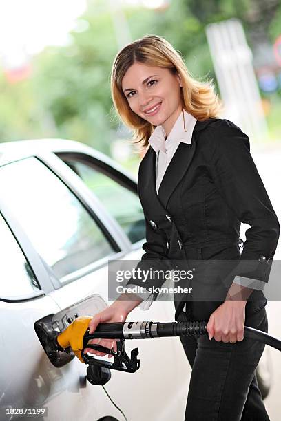 woman pumping gas in gas-station. - gas station friends stock pictures, royalty-free photos & images